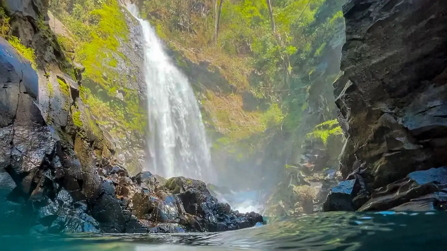 Une chute d'eau au milieu d'un plan d'eau.