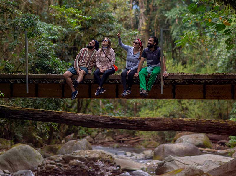 Un groupe de personnes assises sur un pont enjambant une rivière.