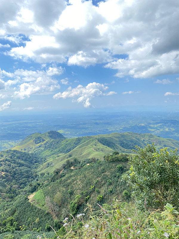 Vue panoramique d'une chaîne de montagnes avec des nuages dans le ciel.