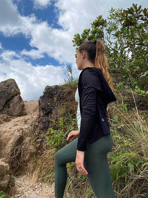Une femme vêtue d'un haut noir et d'un legging vert