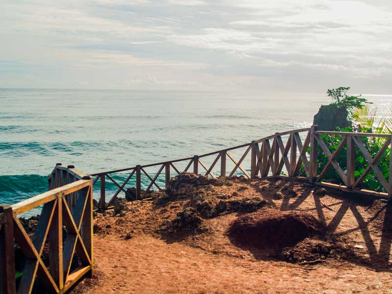 Une passerelle en bois menant à l'océan par temps nuageux.