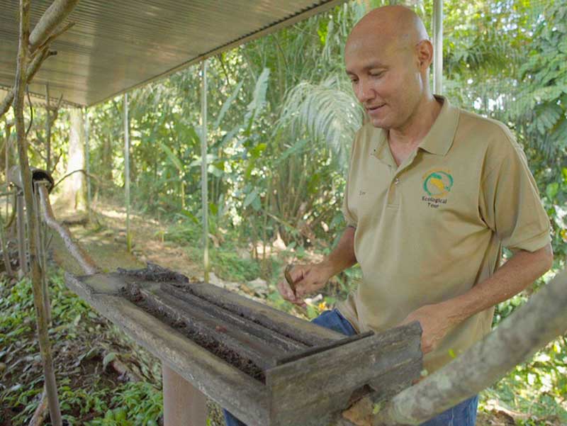 Un homme debout à côté d'une boîte en bois.