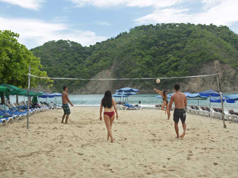 Un groupe de personnes jouant au volley-ball sur une plage.