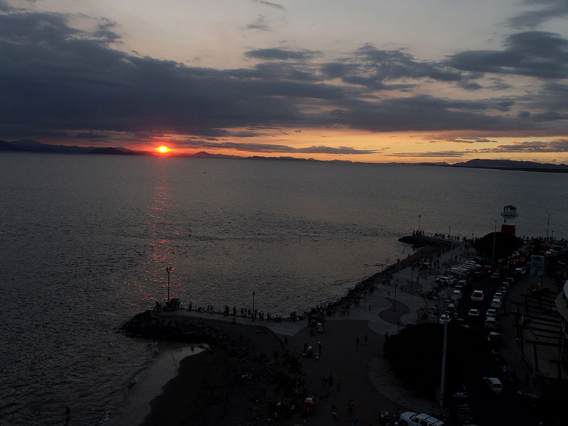 Une grande étendue d'eau avec un coucher de soleil en arrière-plan.
