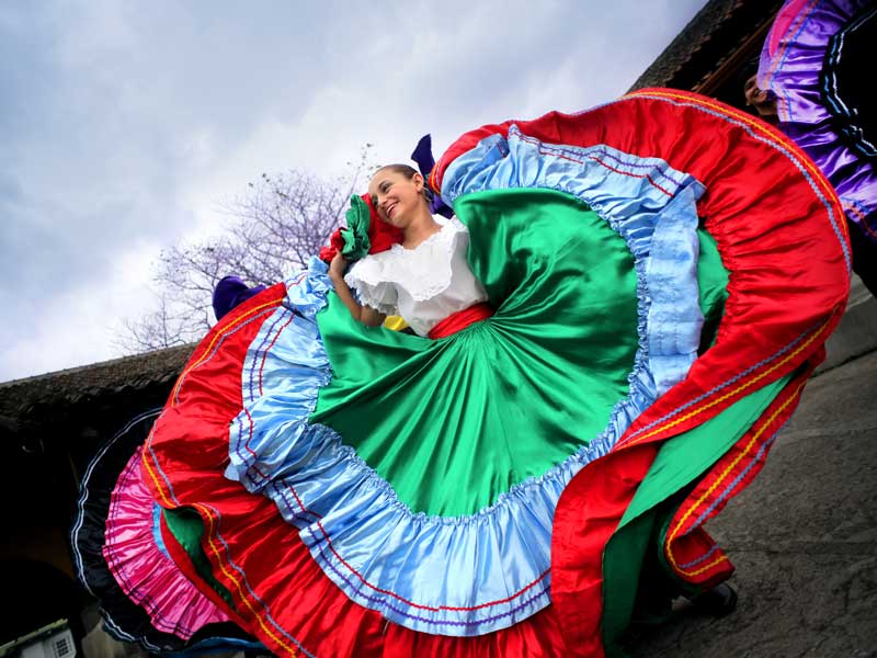 Une femme vêtue d'une robe colorée danse.