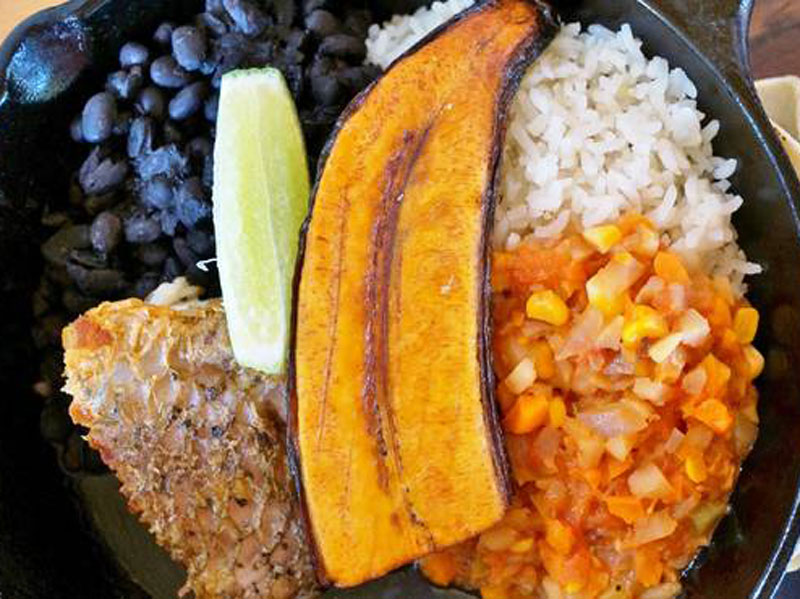 Assiette de nourriture contenant du riz, des haricots et de la viande.