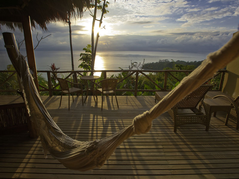 Un hamac sur une terrasse avec vue sur l'océan.