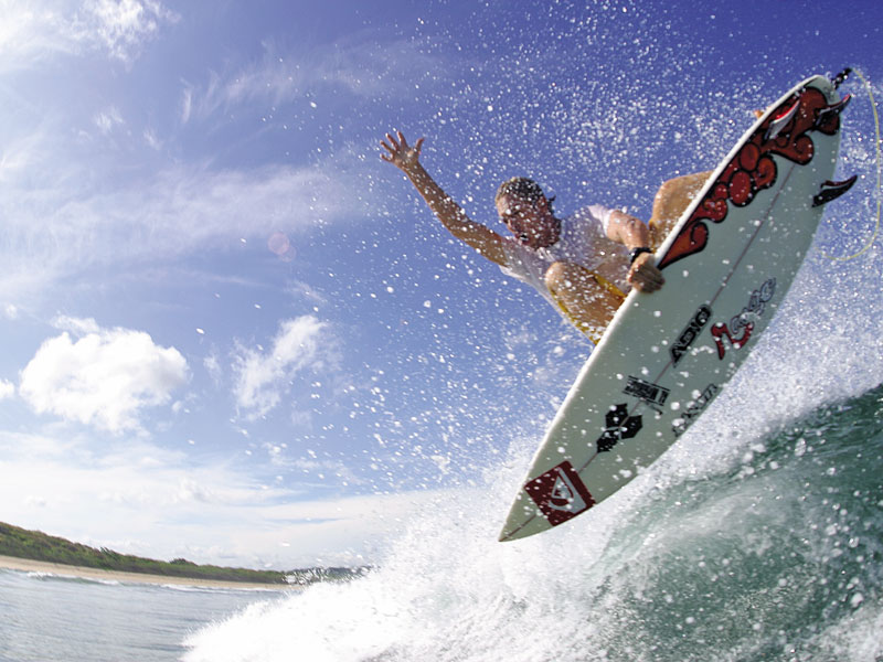 Un homme surfe sur une vague au sommet d'une planche de surf.