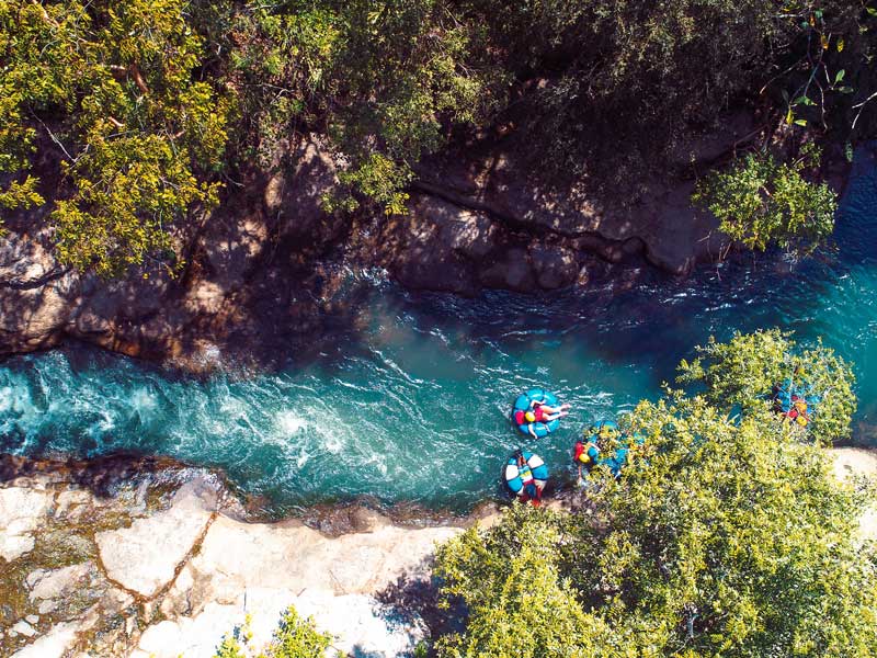 Un groupe de personnes dans des radeaux descendant une rivière.