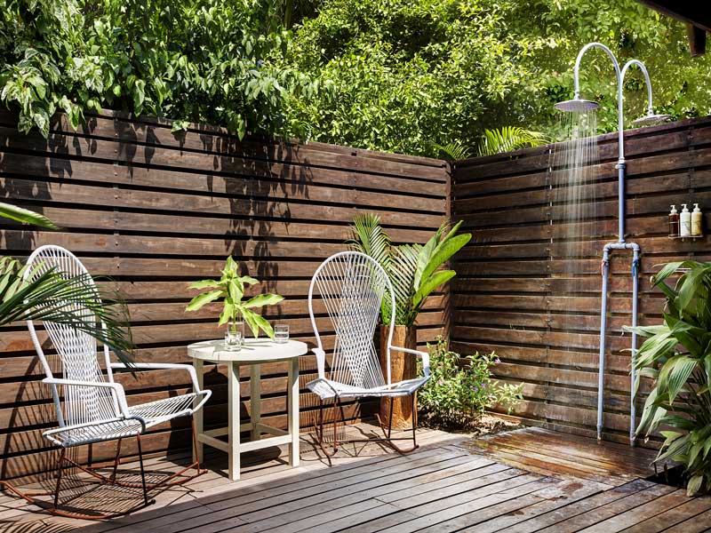 Une terrasse en bois avec deux chaises et une table.