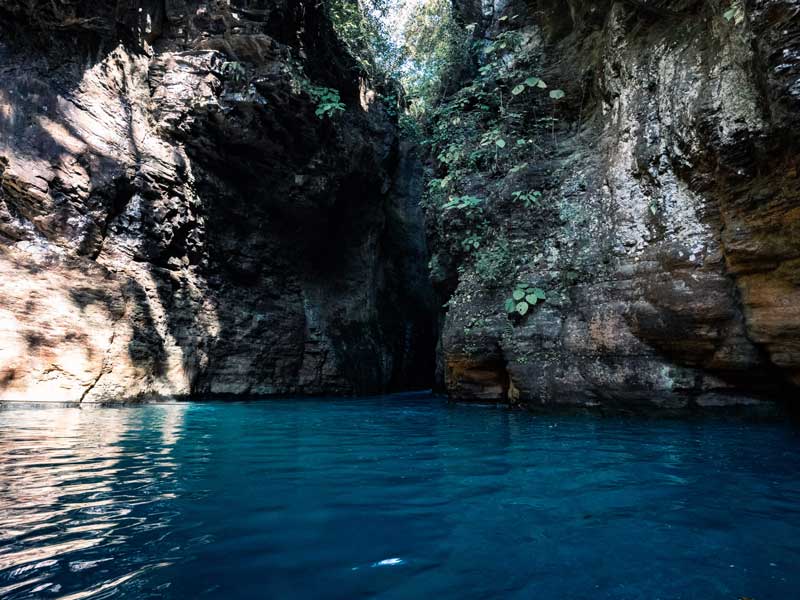 Une étendue d'eau entourée d'une falaise rocheuse.