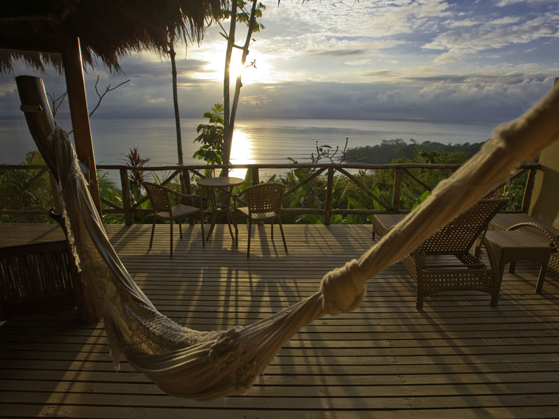Un hamac sur une terrasse avec vue sur l'océan.