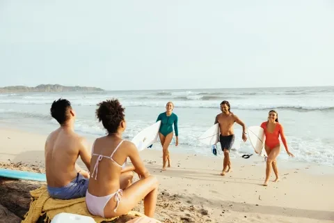 des amis sortant de l'eau après avoir surfé à la plage de Guiones