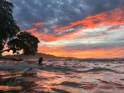 une personne dans l'océan au coucher du soleil