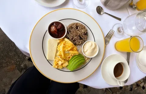 une assiette de petit-déjeuner posée sur une table, accompagnée d'un café et d'un jus d'orange