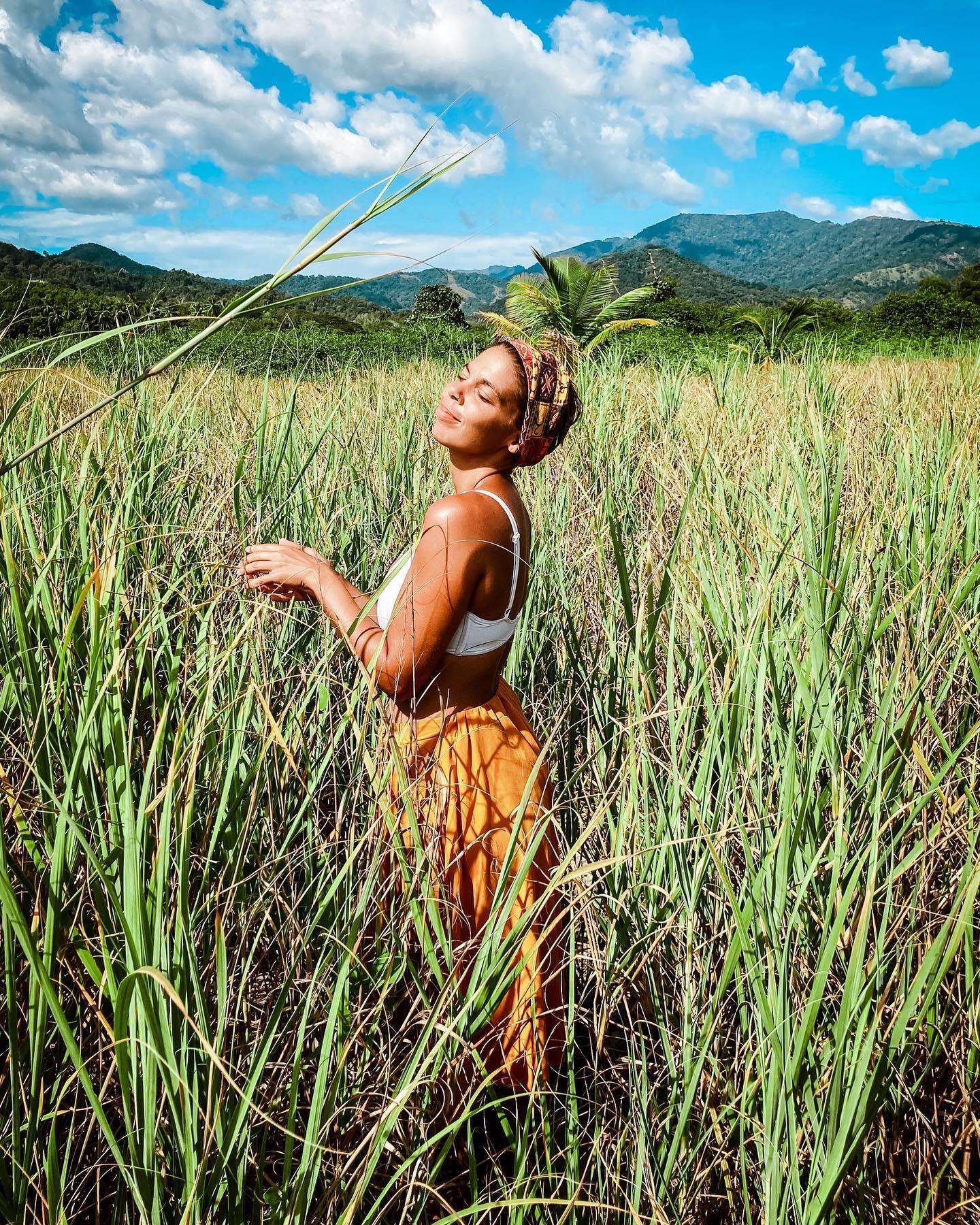 Une femme debout dans un champ d'herbes hautes