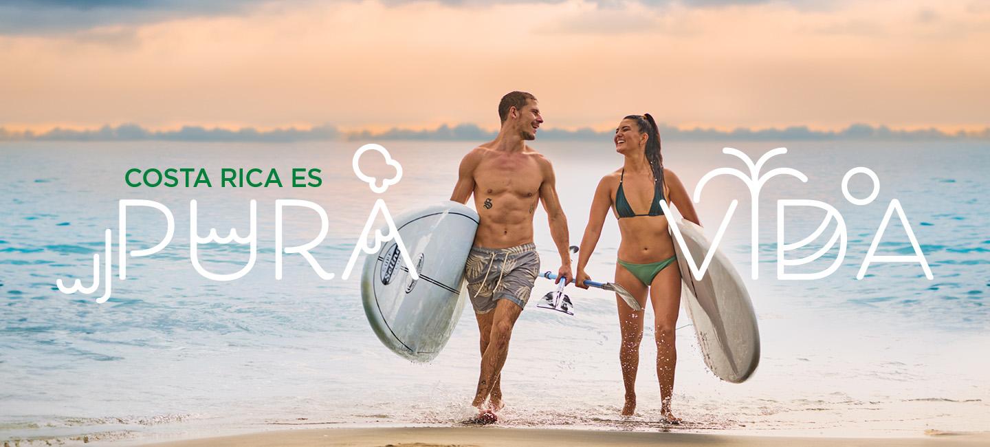 couple marchant sur la plage avec des planches de surf et un textepura vida" autour d'eux