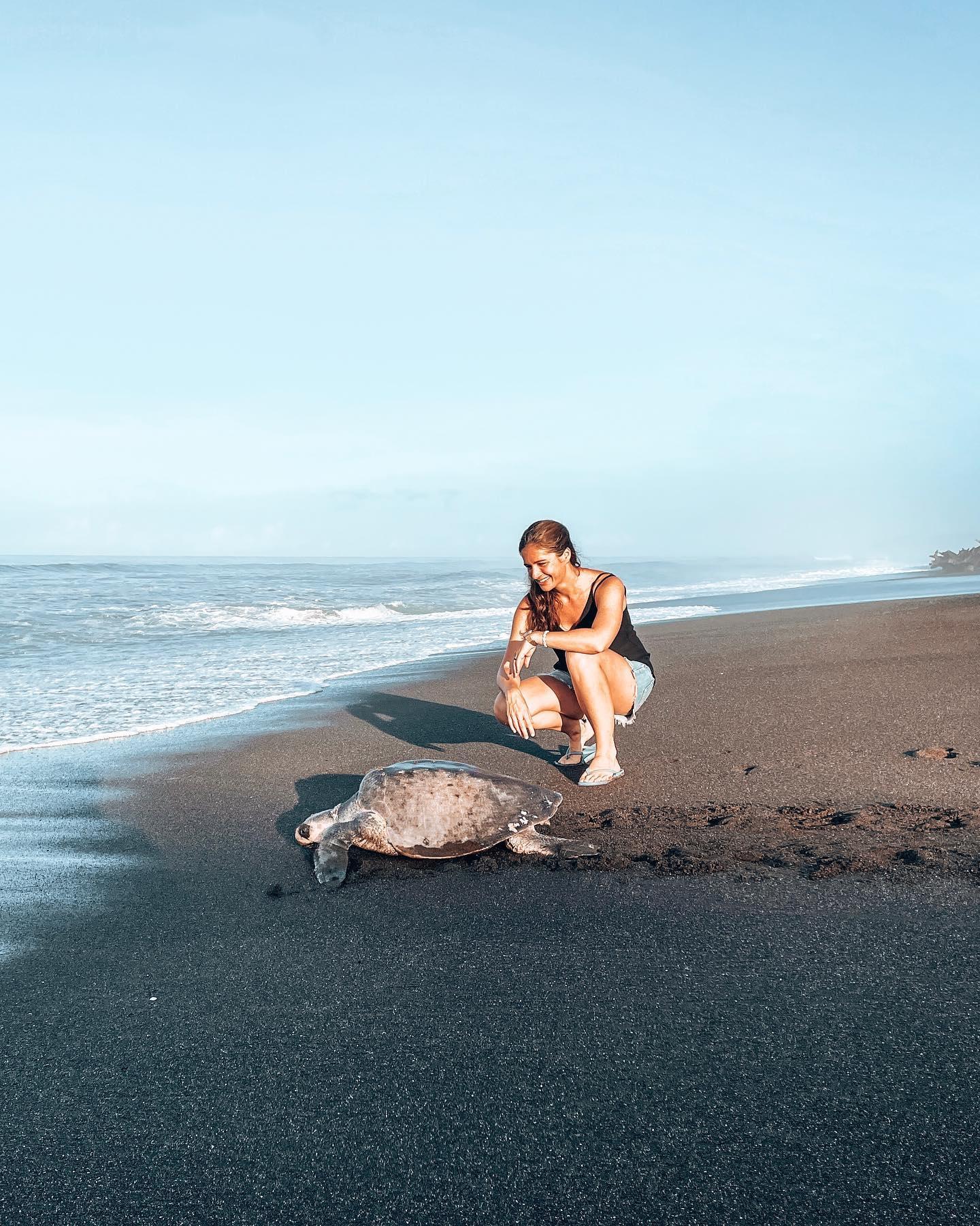 Une femme près d'une tortue sur une plage