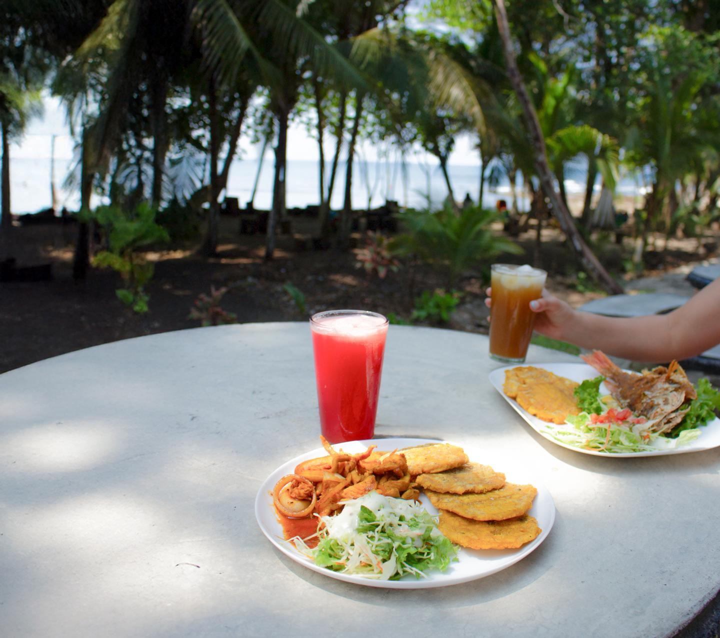deux plats sur une table à l'extérieur avec vue sur la plage