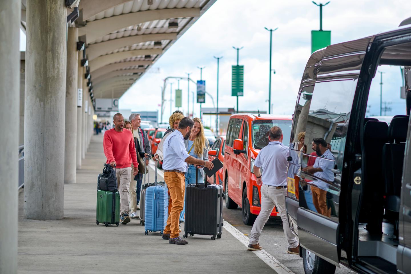 homme aidant une famille à porter des valises à l'aéroport