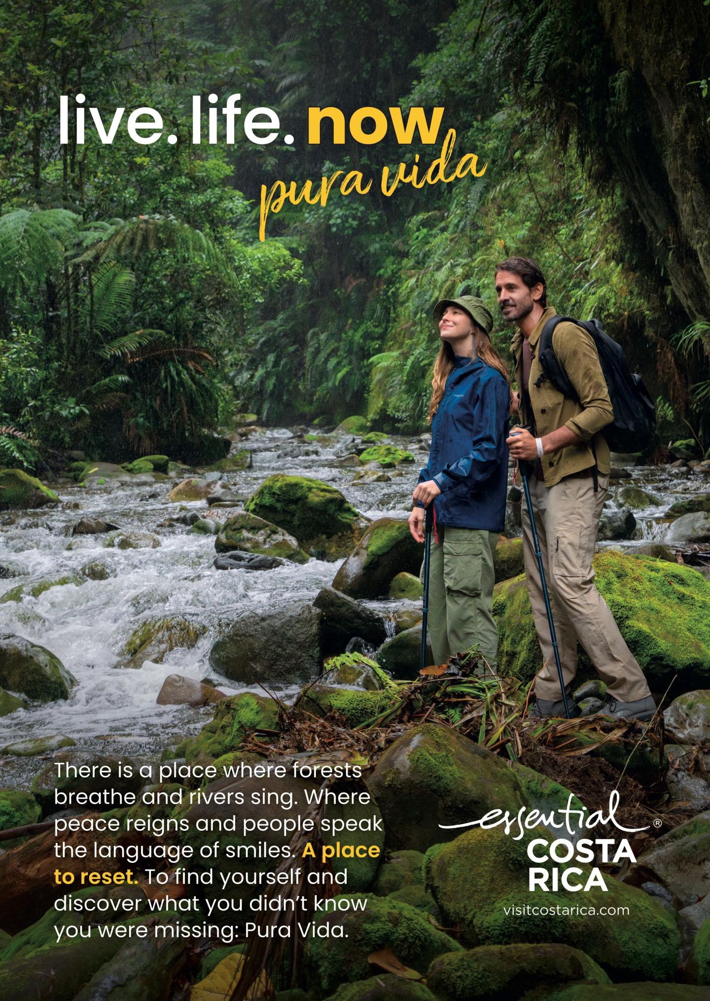 Publicité montrant deux randonneurs debout sur des rochers moussus au bord d'une rivière, dans une forêt tropicale luxuriante. Titres : « live.life.now » et «pura vida». Le texte évoque des forêts qui respirent, des rivières qui chantent et l'occasion de se ressourcer. Logo : « esencial Costa Rica, visitcostarica.com.